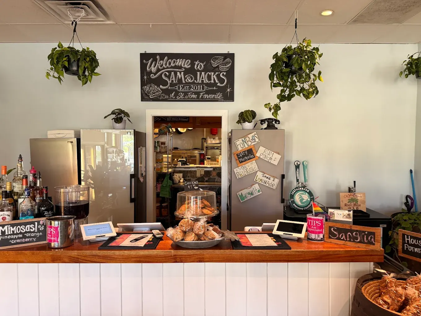 Sam & Jack's Deli counter with the 'Welcome to Sam & Jack's, Est. 2011' chalkboard sign